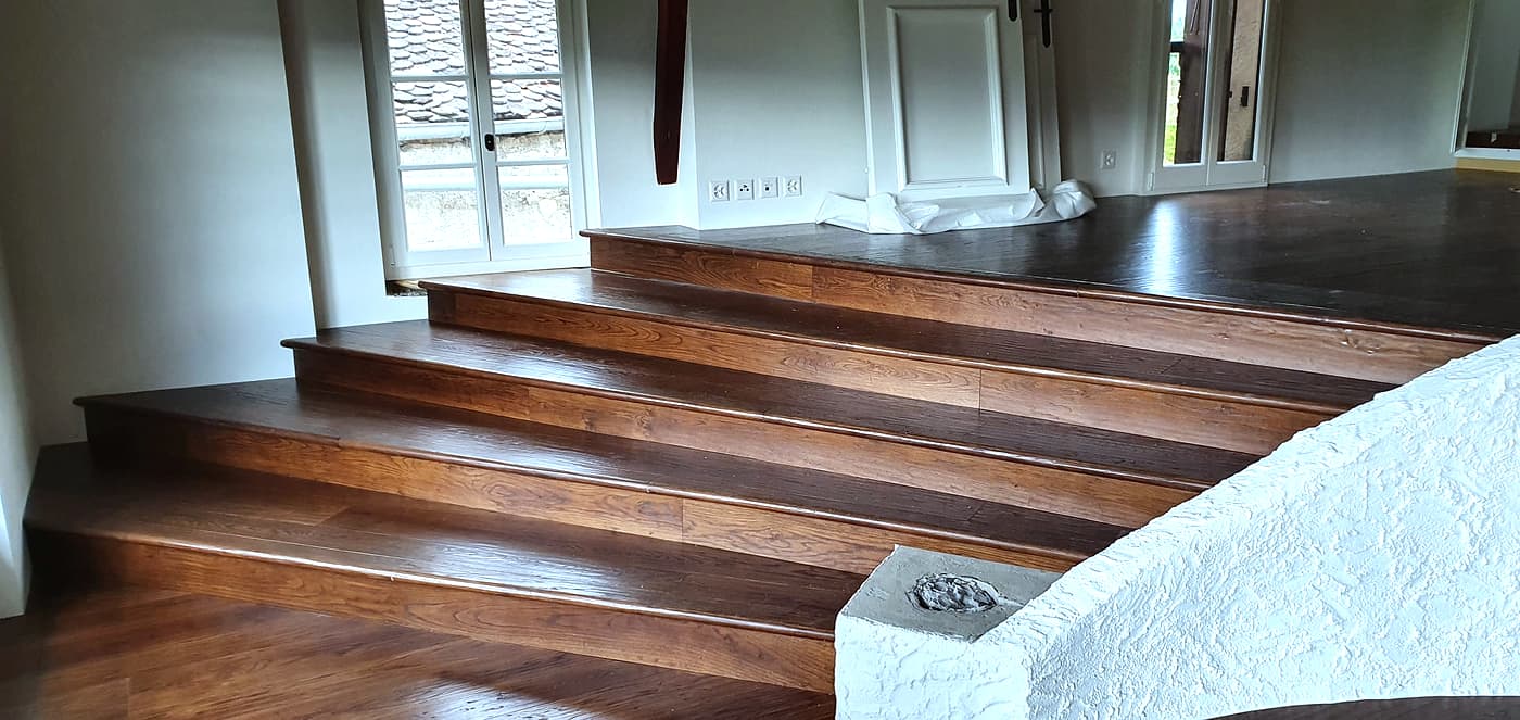 Escalier habillé en bois teinté foncé, marches et contremarches